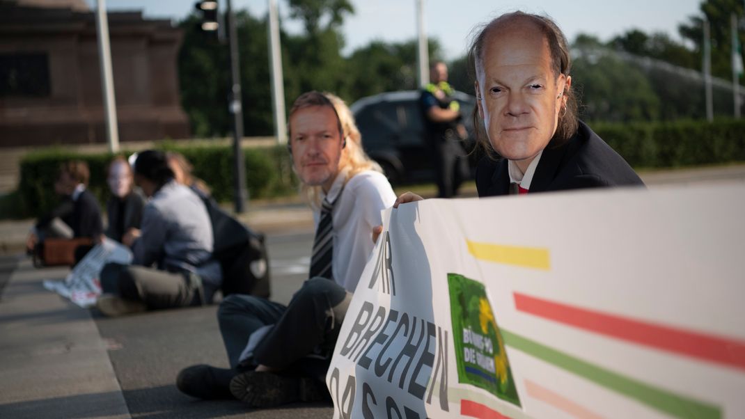 Aktivist:innen der Gruppe Letzte Generation blockieren die Fahrbahnen rund um die Siegessäule. 