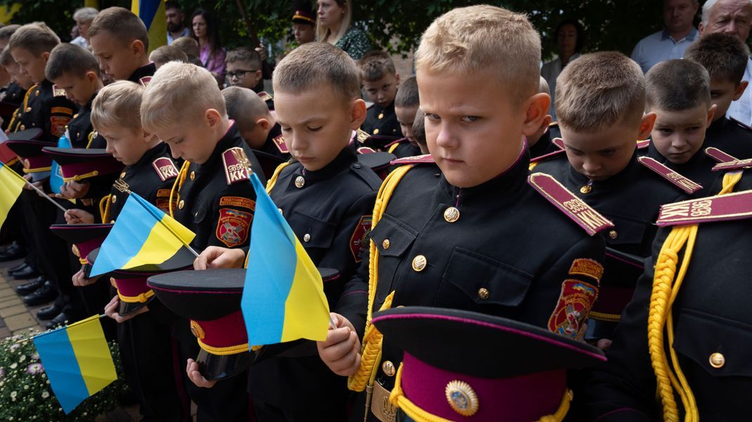 04.09.2023, Ukraine, Kiew: Junge Kadetten halten eine Schweigeminute zum Gedenken an die Absolventen, die im Krieg mit den russischen Streitkräften gefallen sind, während einer Zeremonie am ersten Schultag in einer Kadettenschule. 