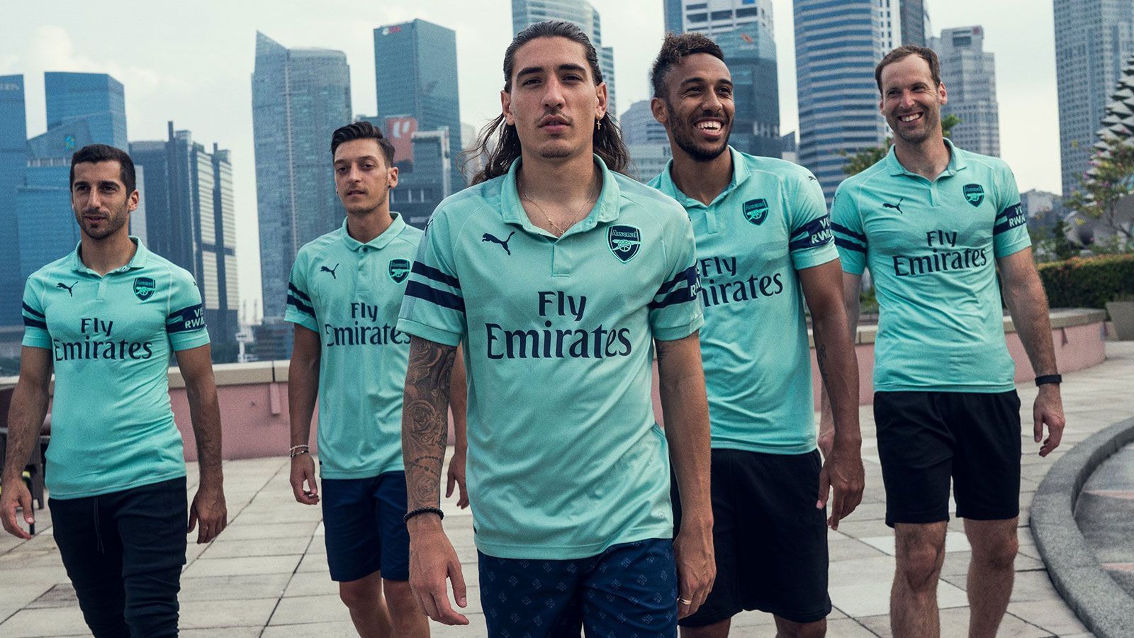 
                <strong>Arsenal Ausweichtrikot</strong><br>
                Der FC Arsenal hat sein neues Ausweichtrikot vorgestellt. Die Gunners werden in der nächsten Saison nicht nur in rot-weiß, sondern auch in "mintgrün" auflaufen. Das Wappen und die Ausrüster-Logo sind, wie die zwei Streifen auf den Ärmeln, dunkelblau. Außerdem befindet sich ein dezenter, gezackter Streifen auf der Brust. Das Trikot kostet in der "Authentic"-Variante 112 Euro und in der regulären Version 62 Euro.
              