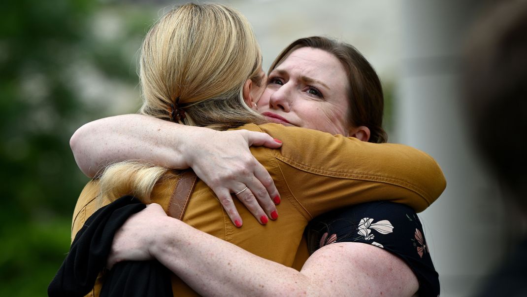 Eine Unterstützerin umarmt Christina Strobel (l.), die Schwester von Simone Strobel, vor dem Lidcombe Coroners Court.