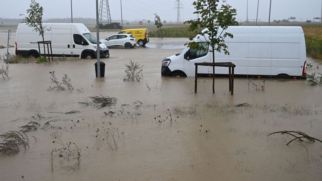 Pkw und Lieferwagen stehen auf einem überfluteten Parkplatz im&nbsp;Wasser. Aufgrund der starken Niederschläge ist am Sonntag ganz Niederösterreich zum Katastrophengebiet erklärt worden.