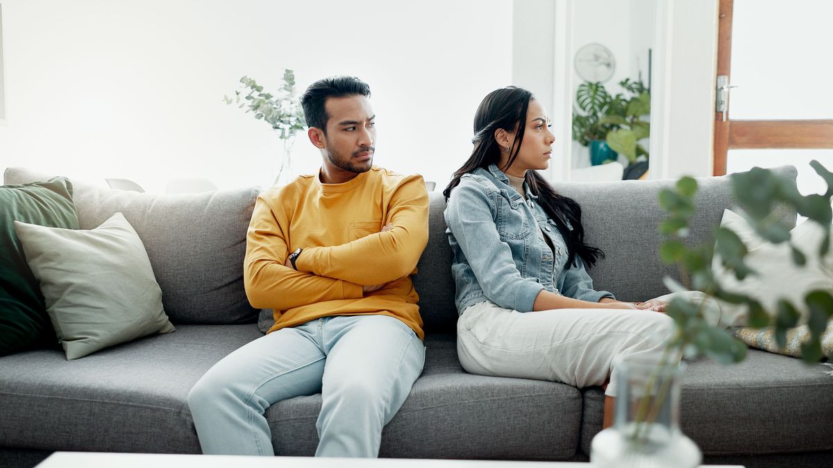 Conflict, fight and couple angry on a couch together duo to infertility, argument and toxic relationship in a home. Unhappy, divorce and man has problem with woman in a living room sofa for cheating