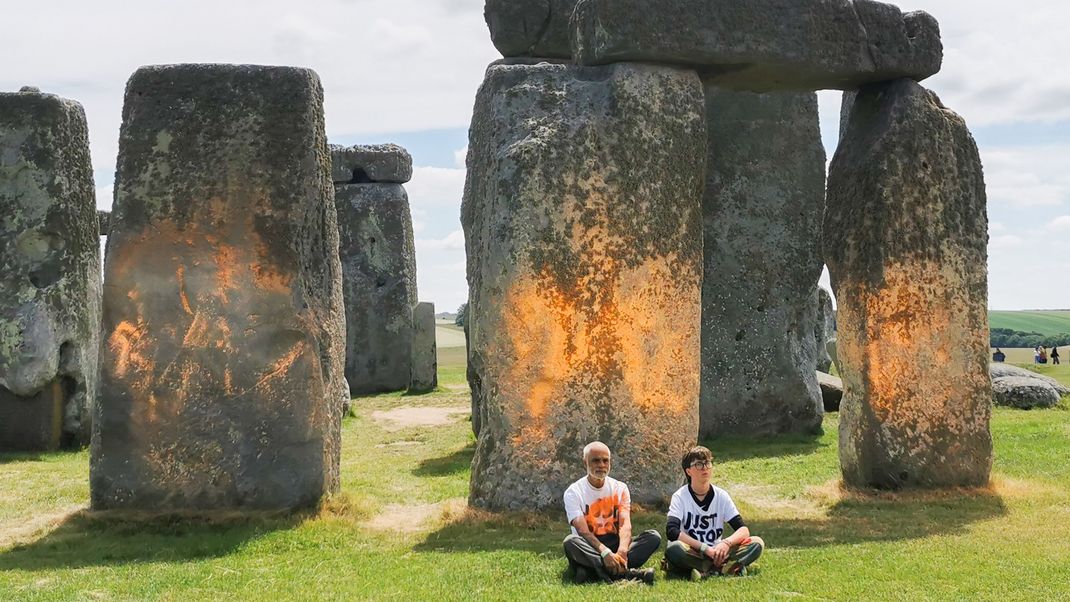 Das Videostandbild zeigt Demonstranten von "Just Stop Oil", die eine orangefarbene Substanz auf Stonehenge gesprüht haben.