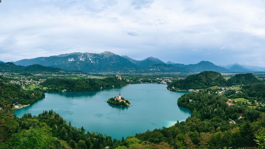 Das solltest du se(e)hen! Der Bleder See im Landesinneren von Slowenien mit seinem Wahrzeichen: Auf der kleinen Insel im See steht die Kirche Maria Himmelfahrt.