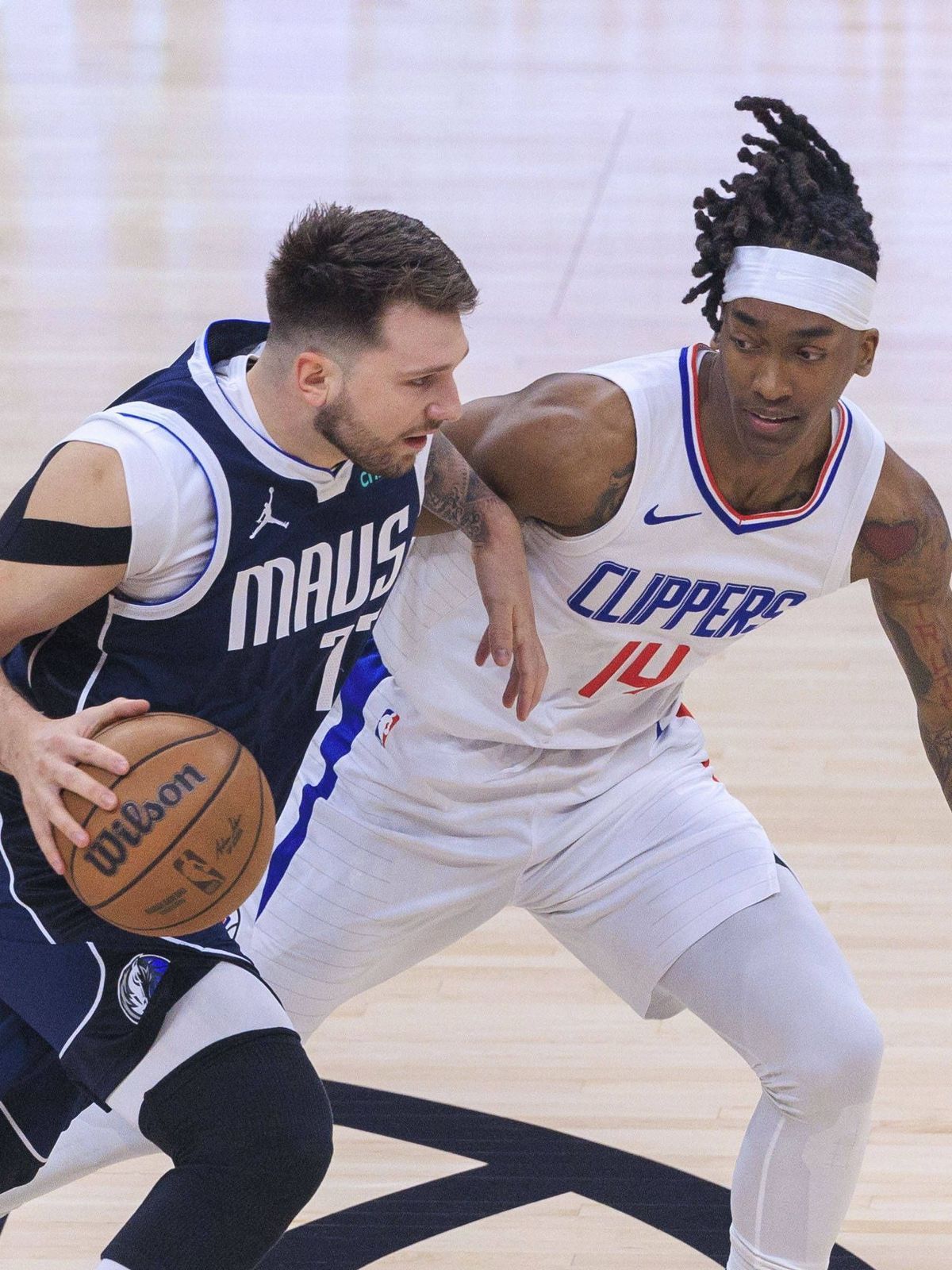 May 1, 2024, Los Angeles, California, USA: Terance Mann 14 of the Los Angeles Clippers defends against Luka Doncic 77 of the Dallas Mavericks during their NBA, Basketball Herren, USA Playoff game f...