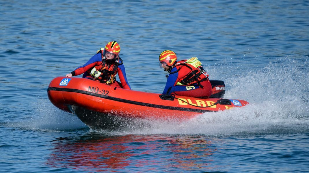 Wasserretter der Deutschen Lebens-Rettungs-Gesellschaft (DLRG) fahren in einem Schnellboot über den Chiemsee. 