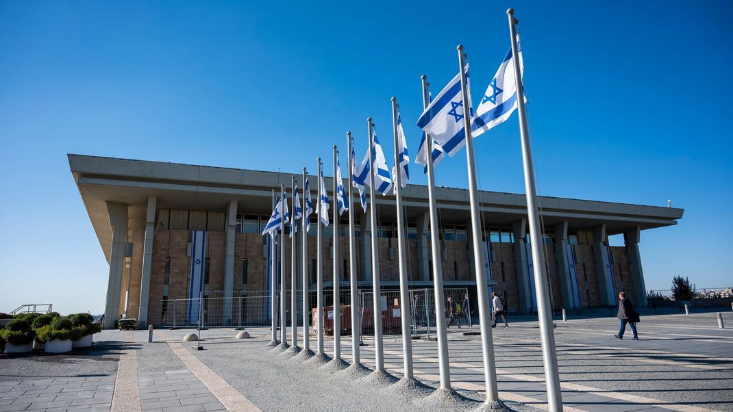 Israel, Jerusalem: Israelische Fahnen wehen vor der Knesset, dem Einkammerparlament des Staates Israel.