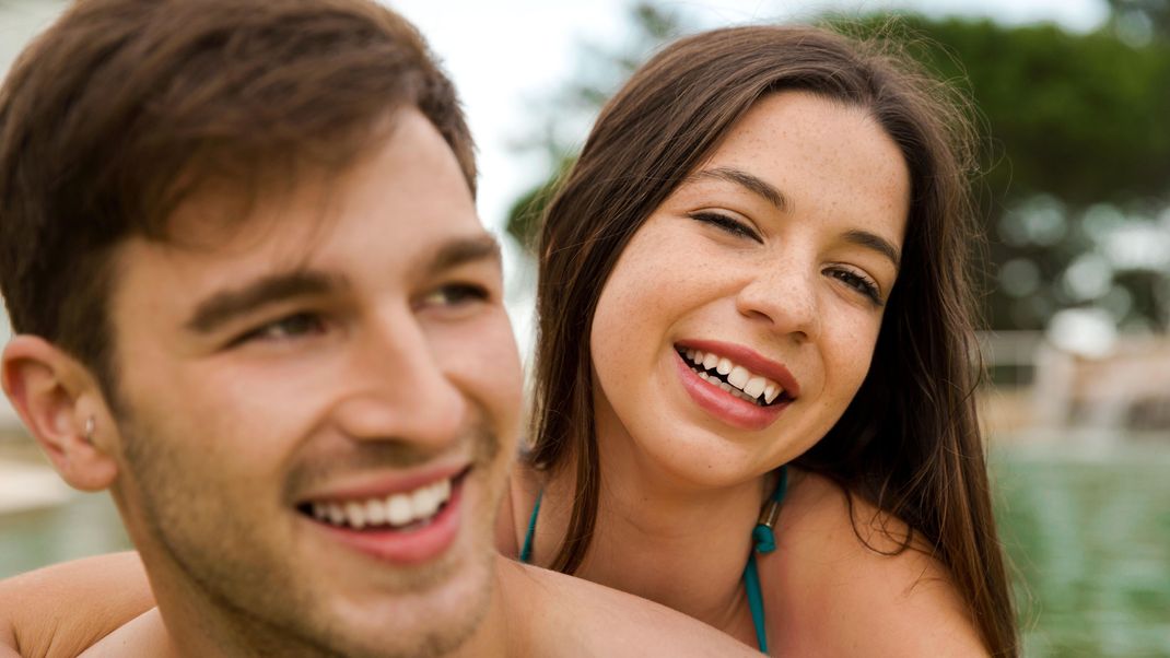 Portrait of a young couple embraced inside the pool || Modellfreigabe vorhanden