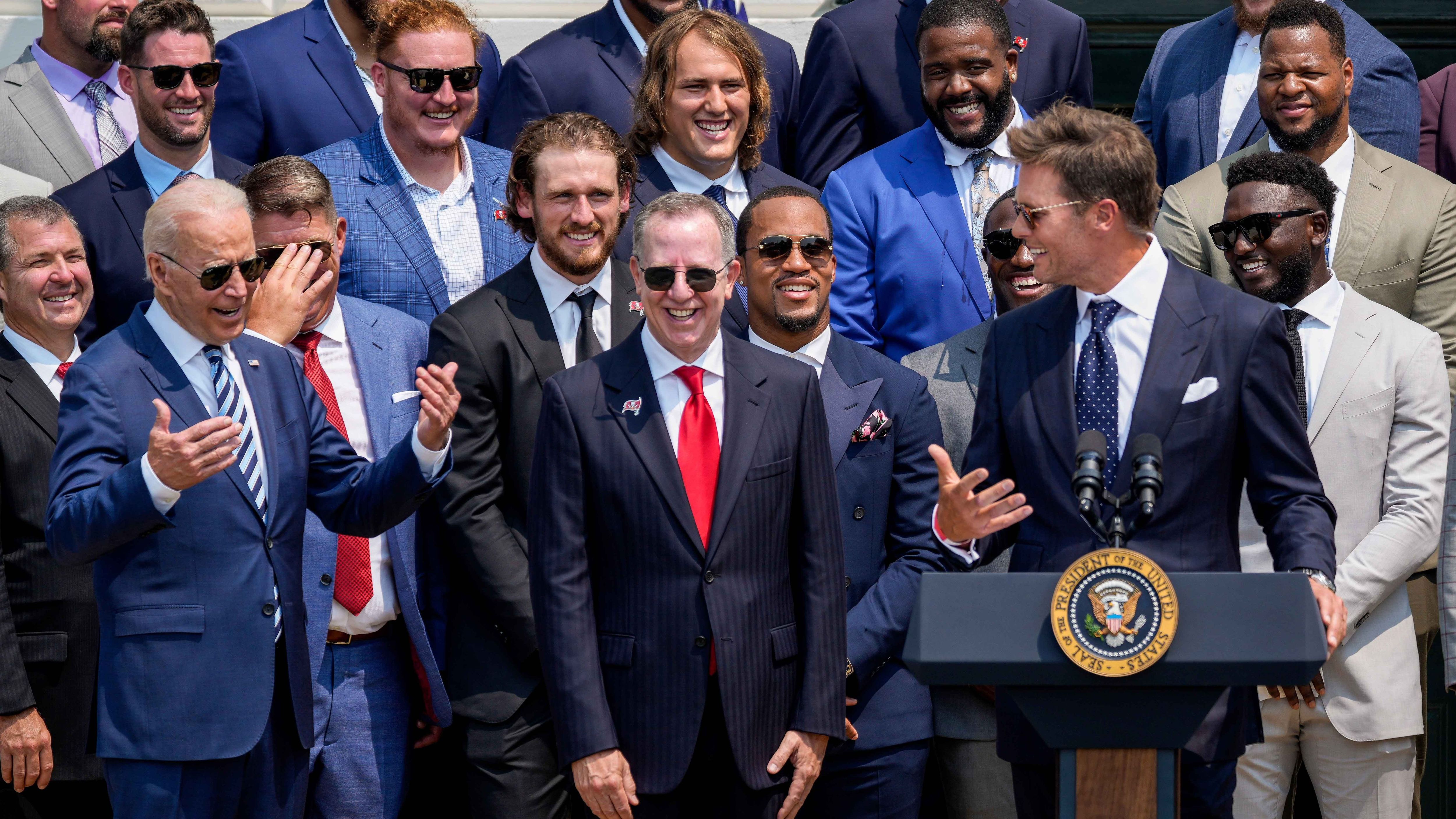 
                <strong>Tom Brady mit Comedy-Auftritt</strong><br>
                Vor allem einer hatte sichtlich Spaß am Besuch: Tom Brady. Der 43-Jährige scherzte in seiner Rede, was das Zeug hielt, machte unter anderem Witze über Bidens Alter, die US-Wahl sowie seinen Appell an die NFL-Spieler, sich doch bitte impfen zu lassen. Auch eine Spitze gegen Donald Trump konnte sich der Quarterback nicht verkneifen: "Nicht viele hätten gedacht, dass wir gewinnen können. Tatsächlich denke ich, dass ungefähr 40 Prozent der Leute immer noch nicht glauben, dass wir gewonnen haben." Eine Anspielung auf die US-Wahl, die Trump noch immer nicht anerkennen will.
              