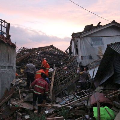 Rettungskräfte in Indonesien suchen nach Überlebenden in den Ruinen von Häusern.