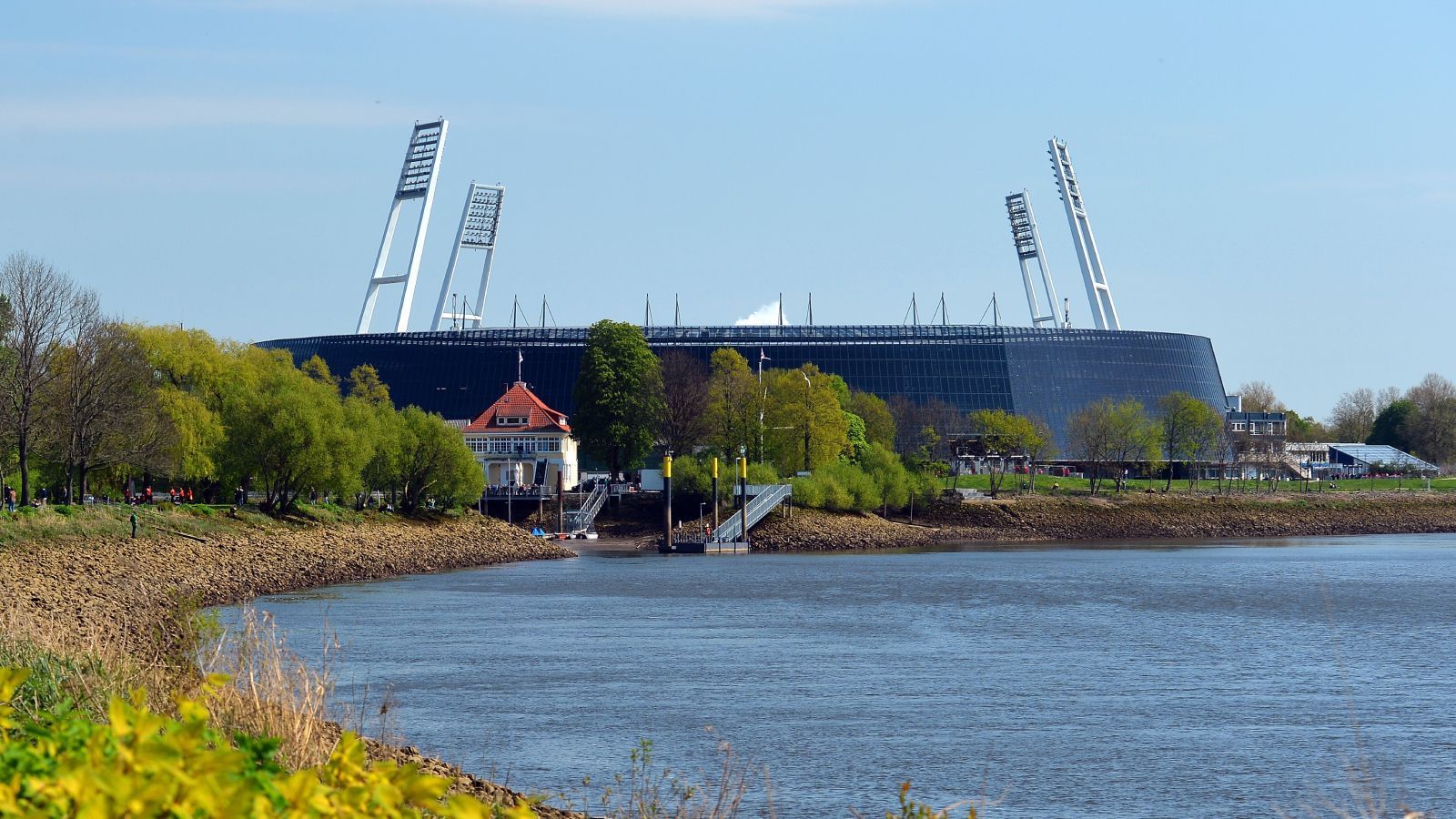 
                <strong>Platz 2: Weserstadion (Werder Bremen)</strong><br>
                Einen hervorragenden Platz zwei hat sich das Bremer Weserstadion gesichert. Ähnlich wie in Stuttgart wurde die Arena in Bremen vor einigen Jahren umgebaut. Dadurch ist sie nicht nur nachhaltiger geworden (Photovoltaik-Anlagen rund ums Stadion), sondern die Zuschauer sind viel näher am Spielgeschehen dran. Der Weg zur Spielstätte hin fühlt sich aufgrund der Lage gemeinhin auch nicht wie ein obligatorischer Fußmarsch an, sondern wie ein idyllischer Spaziergang am Weserstrand. Kleiner Minuspunkt: Von außen betrachtet sieht es aus, als wäre ein riesiges Ufo direkt an der Weser gelandet.
              