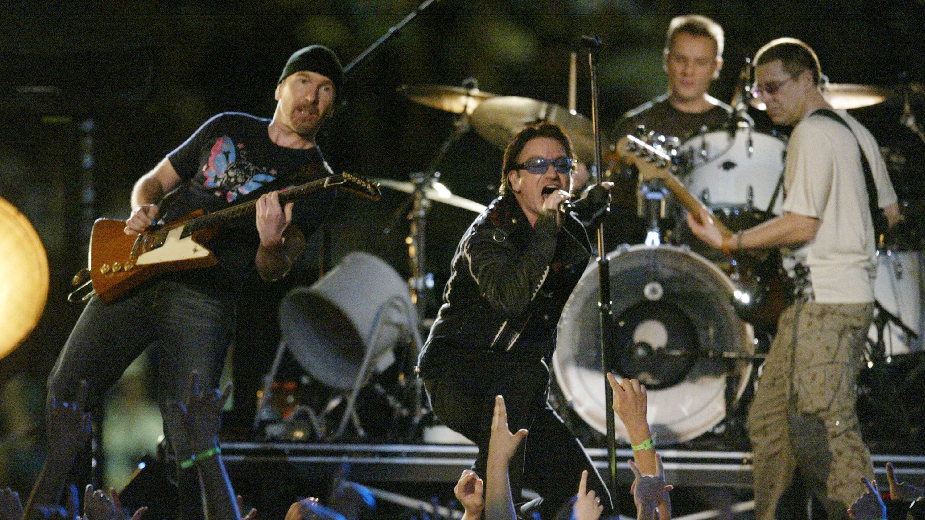 <strong>2002: U2</strong><br>
                Der Super Bowl 2001 war der erste nach den 9/11-Angriffen.&nbsp;Bono und U2 zollten der nationalen Tragödie Tribut und spielten "Where the Streets Have No Name" vor dem Hintergrund der Namen der Opfer vom 11. September. Bono öffnete seine Jacke, um die Stars &amp; Stripes im Inneren zu zeigen, was diese Halbzeitshow zu einer besonders emotionalen Show machte.
