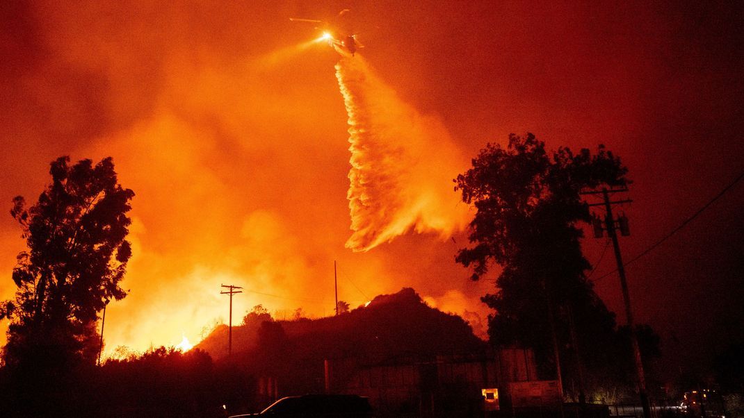 USA, Santa Paula: Ein Hubschrauber schüttet in der Nähe von Santa Paula, Kalifornien, Wasser auf die Flammen des Mountain Fire.