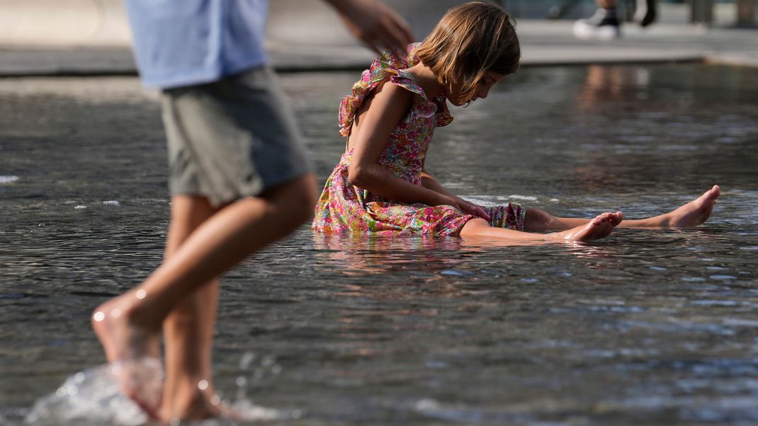 Italien, Mailand: Kinder erfrischen sich in einem Brunnen. 