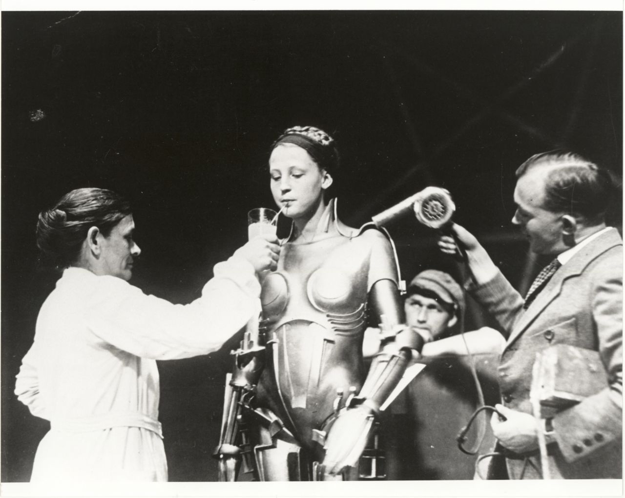 Schon 1927 ließ Regisseur Fritz Lang im Kultfilm "Metropolis" Schauspielerin Brigitte Helm (hier hinter den Kulissen) als Maschinenfrau Maria auftreten. Das metallisch-schimmernde Kostüm war aus Holz und so schwer, dass sie mehrmals zusammenbrach. Der Stummfilm gilt als erster Science-Fiction-Langfilm und ist Teil des Weltdokumenten-Erbes der UNESCO.