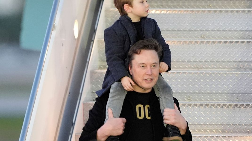 Elon Musk trägt seinen Sohn X Æ A-Xii bei der Ankunft in der Air Force One mit US-Präsident Trump am Palm Beach International Airport in West Palm Beach, Florida.