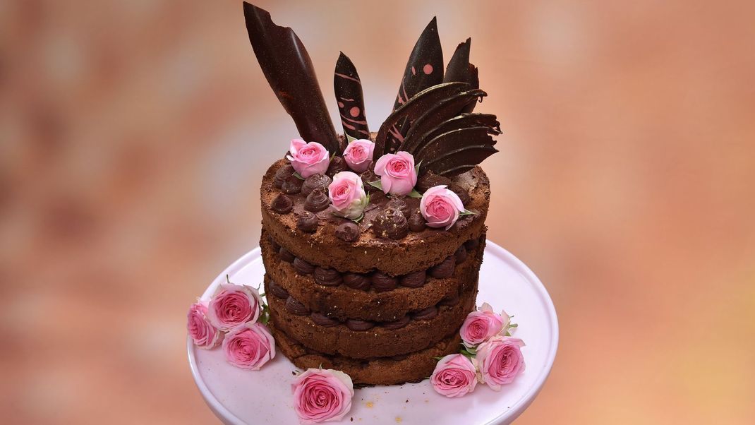 Schoko-Biskuit mit Kirsch- und Kirschblüten-Ganache, Kirschgelee-Kern, Schoko-Dekor und gezuckerten Rosen