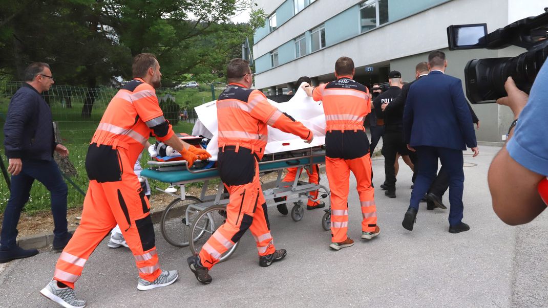 Rettungskräfte bringen den angeschossenen und verletzten slowakischen Ministerpräsidenten Robert Fico auf einer Trage in ein Krankenhaus.