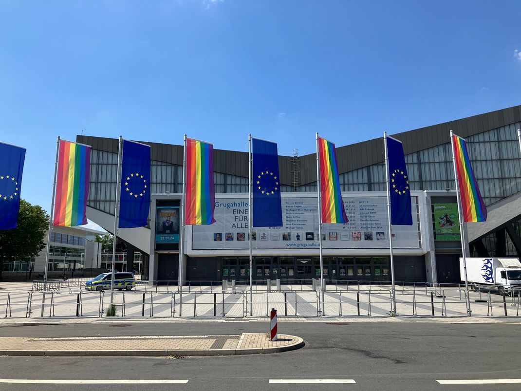 Als Zeichen der Vielfalt wehen vor der Grugahalle in Essen während des AfD-Bundesparteitags Regenbogen- und Europa-Fahnen.