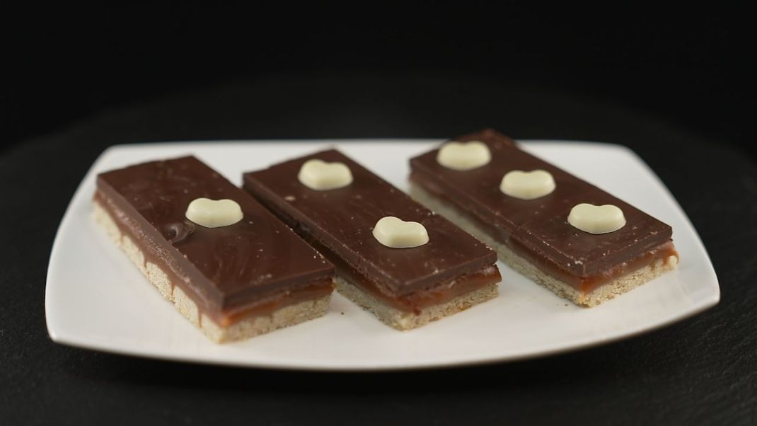 Verlockende Keks-Riegel mit Schokolade- und Karamell-Schichten. Und einfach zu backen sind sie auch! Wir zeigen dir, wie's geht!