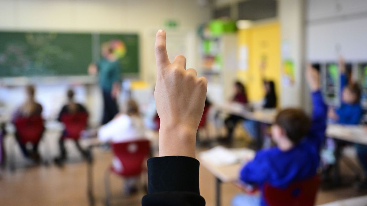 Schüler melden sich in einer vierten Klasse in einer Grundschule.