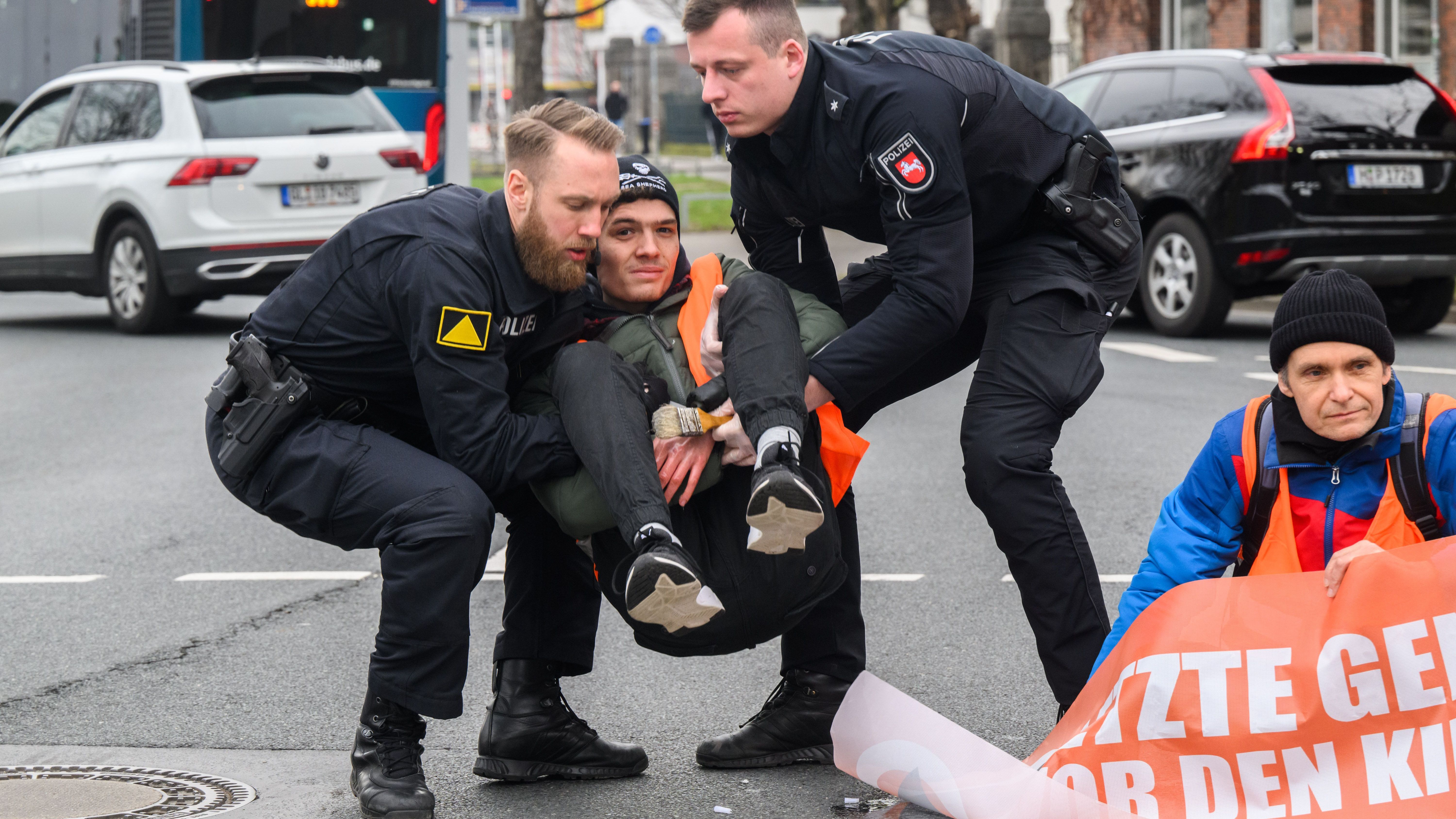 Polizisten in Hannover tragen Klimaaktivist:innen der "Letzten Generation" von der Straße.