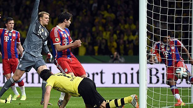 
                <strong>Wembley-Tor einmal anders</strong><br>
                Dieser Treffer zählt nicht. Mats Hummels (vorne) setzt im Pokal-Finale 2014 zwar einen Kopfball hinter die Linie des Bayern-Tores. Doch weil Dante (re.) die Kugel reaktionsschnell wegdrischt, gibt Schiri Florian Meyer die Dortmunder Führung nicht. Stattdessen müssen beide Teams in die Verlängerung, in der der FC Bayern 2:0 siegt.
              