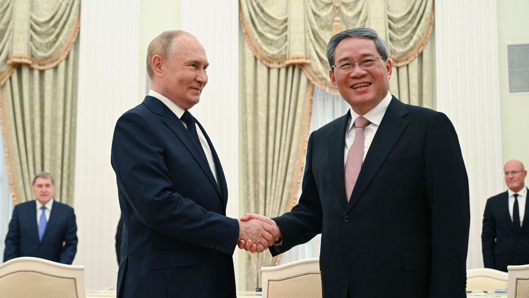 Auf diesem von der staatlichen russischen Nachrichtenagentur Sputnik via AP veröffentlichten Foto gegen sich der russische Präsident Wladimir Putin (l) und der chinesische Ministerpräsident Li Qiang während ihres Treffens im Kreml die Hände.&nbsp;