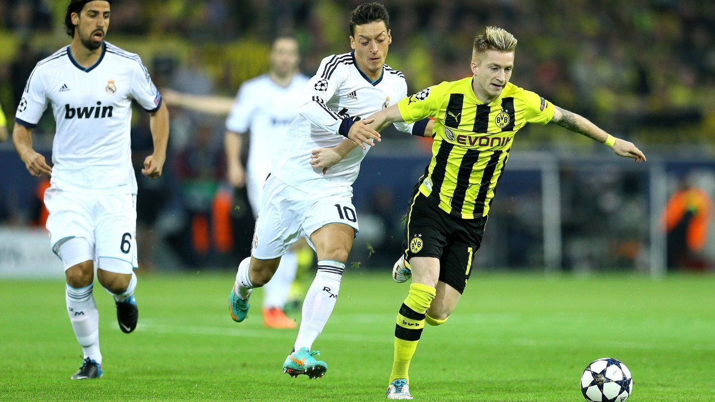 
                <strong>Der tragische Held Marco Reus</strong><br>
                Marco Reus ist vielleicht Dortmunds bester Kicker des vergangenen Jahrzehnts. Wie lange er Schwarzgelb schon treu ist, sieht man auch an diesem Foto seines Champions-League-Auftritts gegen das Real Madrid von Sami Khedira und Mesut Özil. Aber wie viel besser wäre seine Bilanz, sein Ruf, seine Karriere, wenn das BVB-Urgestein von Verletzungen verschont geblieben wäre? Balsam auf der Seele jedes Fußball-Romantikers, wenn der strahlende Reus als Kapitän endlich die Meisterschale in Empfang nehmen darf.
              