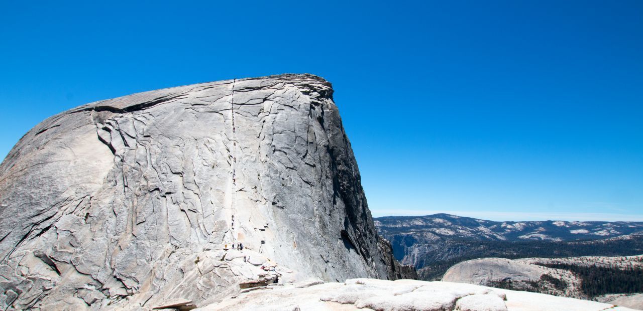 Der knapp 2.700 Meter hohe Half Dome im kalifornischen Yosemite-Nationalpark galt lange als unbezwingbar. Erst 1919 wurden Löcher in die riesige "Halbkugel" gebohrt, um ein Geländer installieren zu können. Und so ermöglichen Stahlseile auf den letzten 120 Höhenmetern, die extreme Steigung (45 Grad und mehr) auf dem glatten, ungestuften Granit zu meistern. Für die gesamte Strecke von rund 25 Kilometern benötigen geübte Wandere